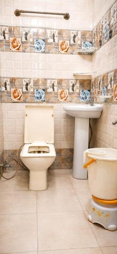 a bathroom with a toilet and a sink at Hotel Atithi Palace in Sahāranpur