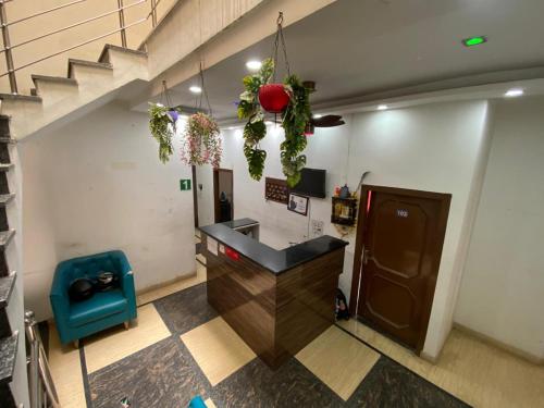 a lobby with a bar with a blue chair and stairs at Fab Krishna hotal in Panchkula