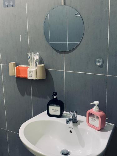 a bathroom sink with a mirror and a soap dispenser at Guest house Trung Hiếu in Rạch Giá
