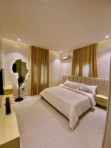 a bedroom with a large bed and a desk at Aulein Apartments in Abuja