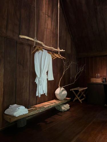 a white shirt hanging on a wooden wall at Sadela Retreat in Ấp Câm Sơn (2)