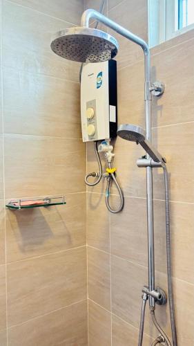 a shower in a bathroom with a shower head at Seaview Apartment in Kuah