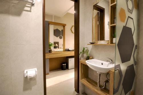 a bathroom with a sink and a mirror at Casananta Seminyak in Seminyak