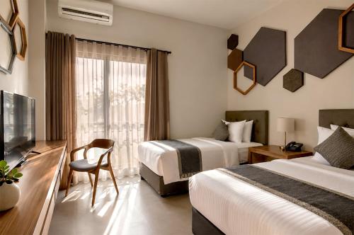 a hotel room with two beds and a television at Casananta Seminyak in Seminyak