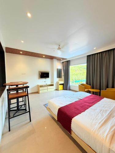 a bedroom with a bed and a desk and a table at The Berry House in Satara