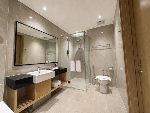 a bathroom with a sink and a shower and a toilet at Prime Plaza Hotel Mataram in Mataram