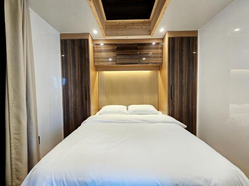 a bedroom with a large white bed in it at Udo Chano Village in Jeju