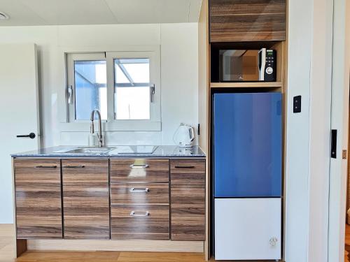 a kitchen with a sink and a refrigerator at Udo Chano Village in Jeju