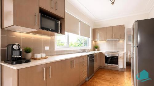 a kitchen with wooden floors and stainless steel appliances at Driftwood at Blacksmiths in Blacksmiths