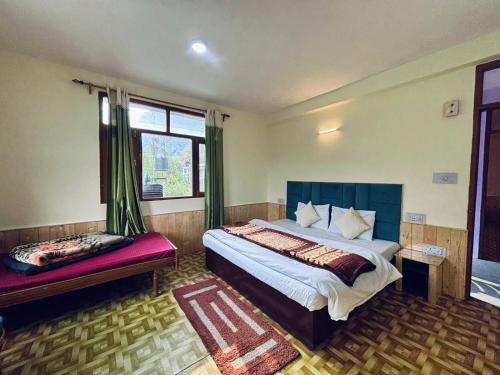 a bedroom with a large bed and a window at Non Stop Cafe Hostel & Stay in Manāli