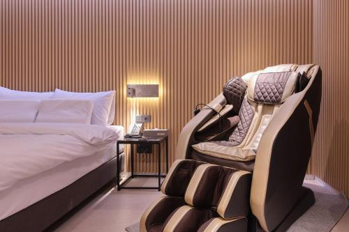 a hotel room with a bed and a chair at Seocho JS Hotel in Seoul