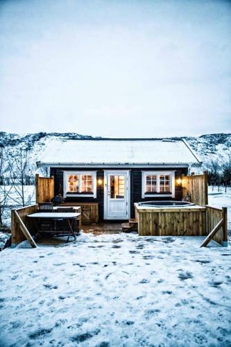 ein Haus mit Schnee auf dem Boden davor in der Unterkunft Akurgerði Guesthouse 2 - Country Life Style in Ölfus