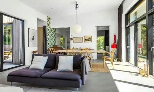 a living room with a purple couch and a dining room at Architect Villa By Cliff Bathing In High Coast in Härnösand