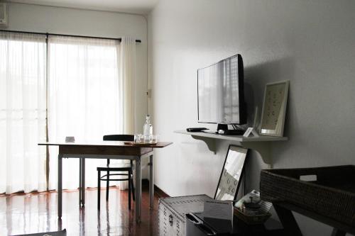 a living room with a desk with a computer on it at Aster 9 House in Bangkok