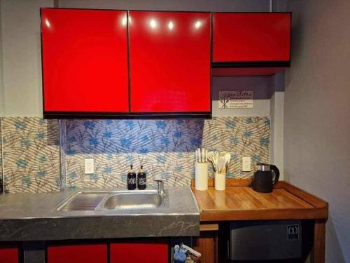 a kitchen with a sink and red cabinets at S & R Homes in Tacloban