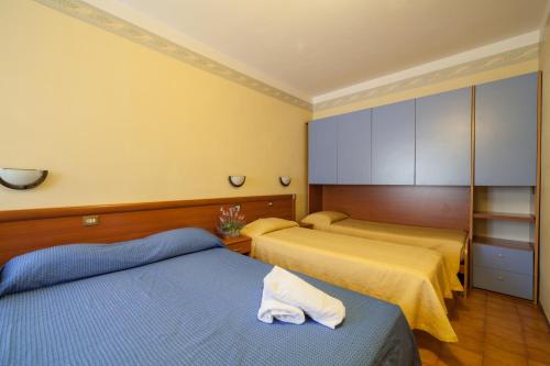 two beds in a room with yellow walls at Hotel Ricordo Du Parc in Tabiano