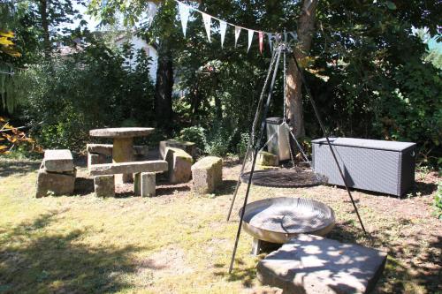 a garden with a stonehenge and a table and aburning at mein kleinHOTEL in Herbstein