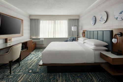 a hotel room with a large bed and a television at Boston Marriott Peabody in Peabody