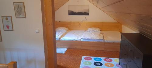 a small room with a bed in the attic at Chalupa u Anenské in Žďárský Potok