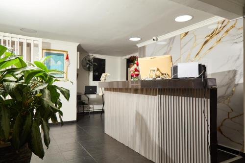 eine Bürolobby mit Empfangstresen und Pflanzen in der Unterkunft Hotel plata inn in Villavicencio