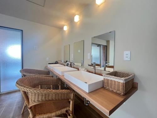 a bathroom with three sinks and two mirrors at 秘湯花文 in Myoko