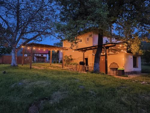 a house with lights on the side of it at Вила Хармония Harmony Cottage in Kyustendil