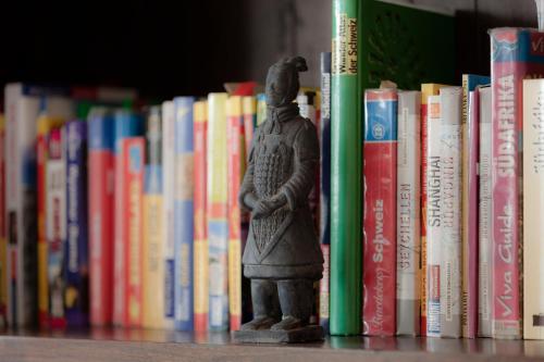 a statue sitting on a shelf in front of books at mein kleinHOTEL in Herbstein