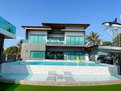 a house with a swimming pool in front of a building at Sky Beach Pool Villa Chanthaburi 2 in Laem Sing