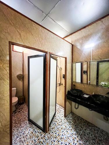a bathroom with a shower and a sink and a toilet at Tam Coc Central Backpacker Hostel in Vũ Lâm