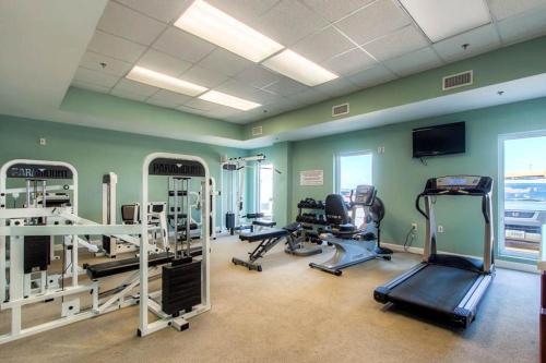 a gym with several tread machines and a flat screen tv at Seychelles Resort by Panhandle Getaways in Panama City Beach