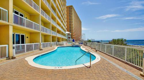 a swimming pool in front of a building with the ocean at Seychelles Resort by Panhandle Getaways in Panama City Beach