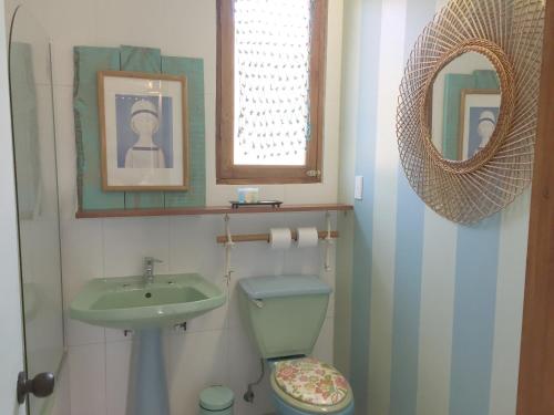 a bathroom with a sink and a toilet and a mirror at Casapapudo Boutique Home in Papudo