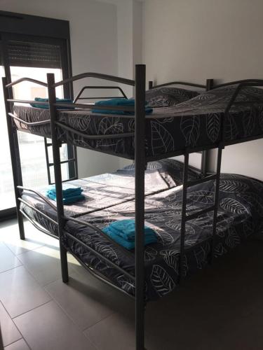 two bunk beds in a room with a window at Penthouse Oasis Beach La Zenia in Playas de Orihuela