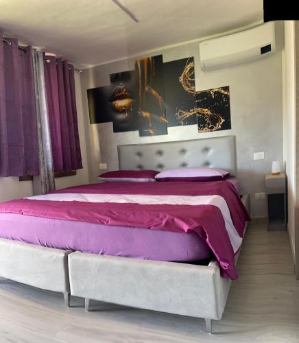 a bedroom with a large bed with purple sheets at B&B Island View in Parzanica