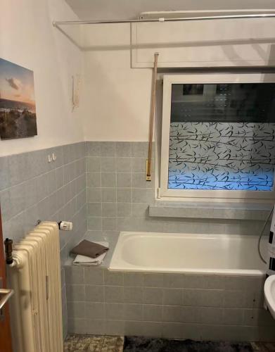 a bathroom with a bath tub and a window at Apartments an der Messe in Düsseldorf