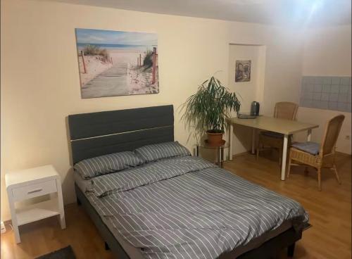 a bedroom with a bed and a table with a plant at Apartments an der Messe in Düsseldorf
