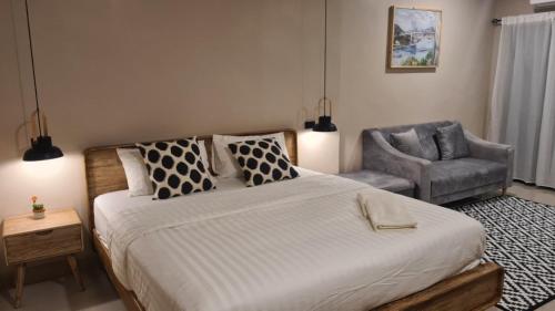 a bedroom with a large bed and a chair at VNL Stay in Trang