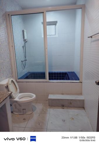 a bathroom with a shower and a toilet at Splash Paradise Villa in Cha Am