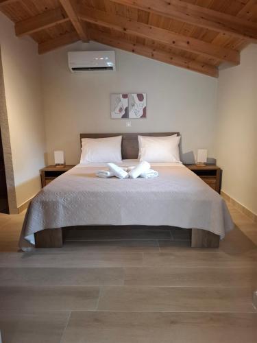 a bedroom with a bed with two towels on it at Stones villa corfu in Varypatádes