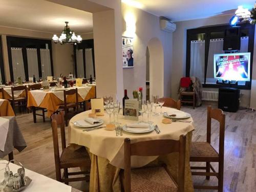 a dining room with tables and chairs and a tv at Hotel Ristorante La Grotta in Castiglione delle Stiviere