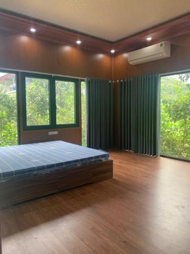 a bedroom with a bed in a room with windows at Educational Eco Ba Vi in Thủ Pháp