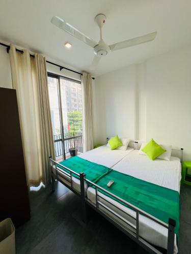 a bedroom with a bed and a large window at VIBE Colombo in Colombo