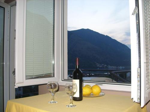 a bottle of wine sitting on a table with two glasses at Apartments Dakovic in Kotor
