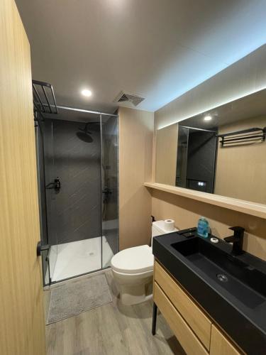 a bathroom with a shower and a toilet and a sink at The Playground in Baras
