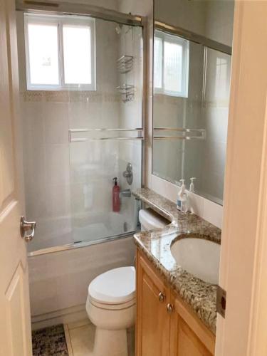 a bathroom with a toilet and a sink and a mirror at 温哥华列治文别墅民宿32 in Richmond