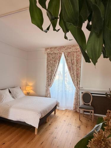 a bedroom with a bed and a large leaf ceiling at Villa des dames 40m2,jardin fleuri in Sainte-Savine