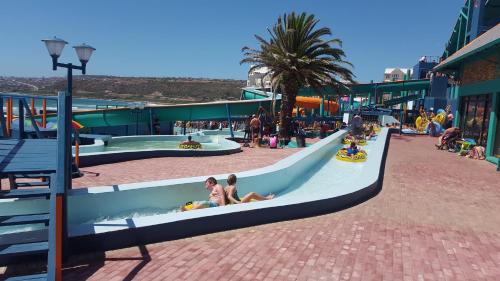 a water park with people riding down a slide at Bayview Selfcatering Apartment in Hartenbos