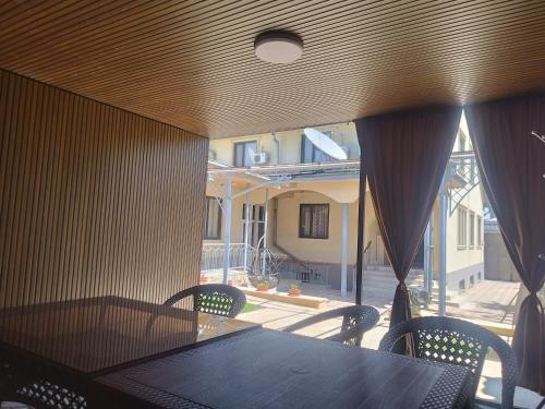a dining room with a table and chairs and a building at Uyut house Osh in Osh