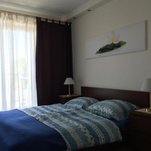a bedroom with a blue bed and a window at Wechta - Promenada Gwiazd 28 with Sea View, Free Rooftop Pool & Sauna in Międzyzdroje