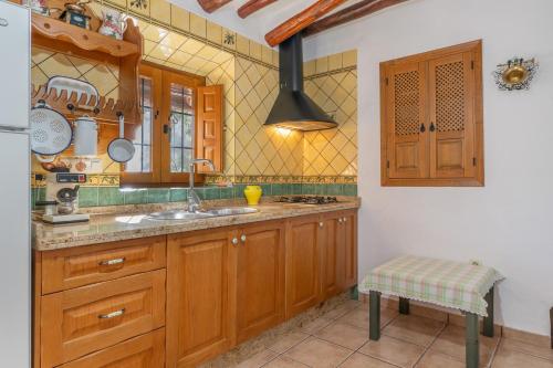 a kitchen with wooden cabinets and a sink at Cortijo Corral del Gallo in Órgiva